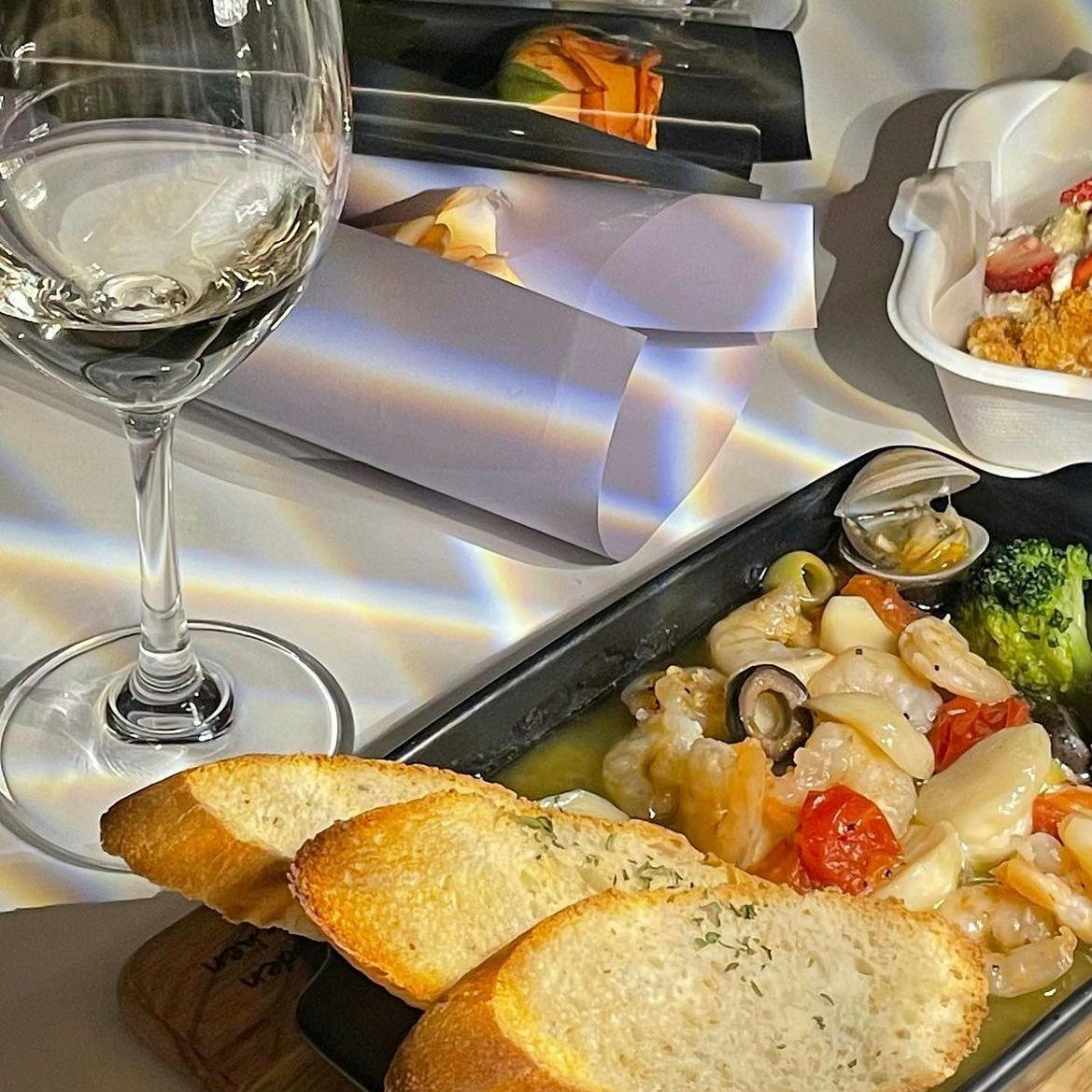 @thehueil_casual_wine_dining의 공식 홍보 사진이다. 감바스와 피자, 와인, 파스타가 나와있다.